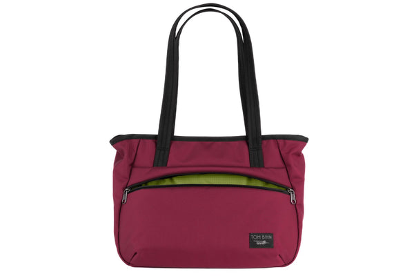 Photo of the Nomad Tote in Raspberry (reddish-purple) Ballistic with Moss (green with light green grid) 210 Cerylon interior.